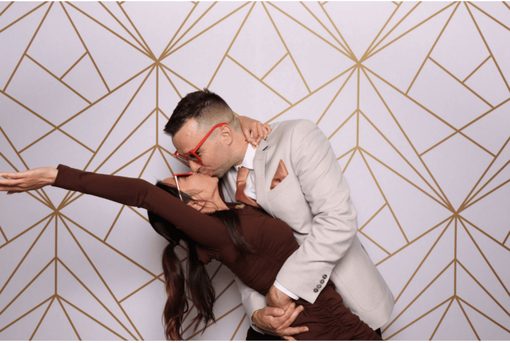 Couple kissing against geometric backdrop.