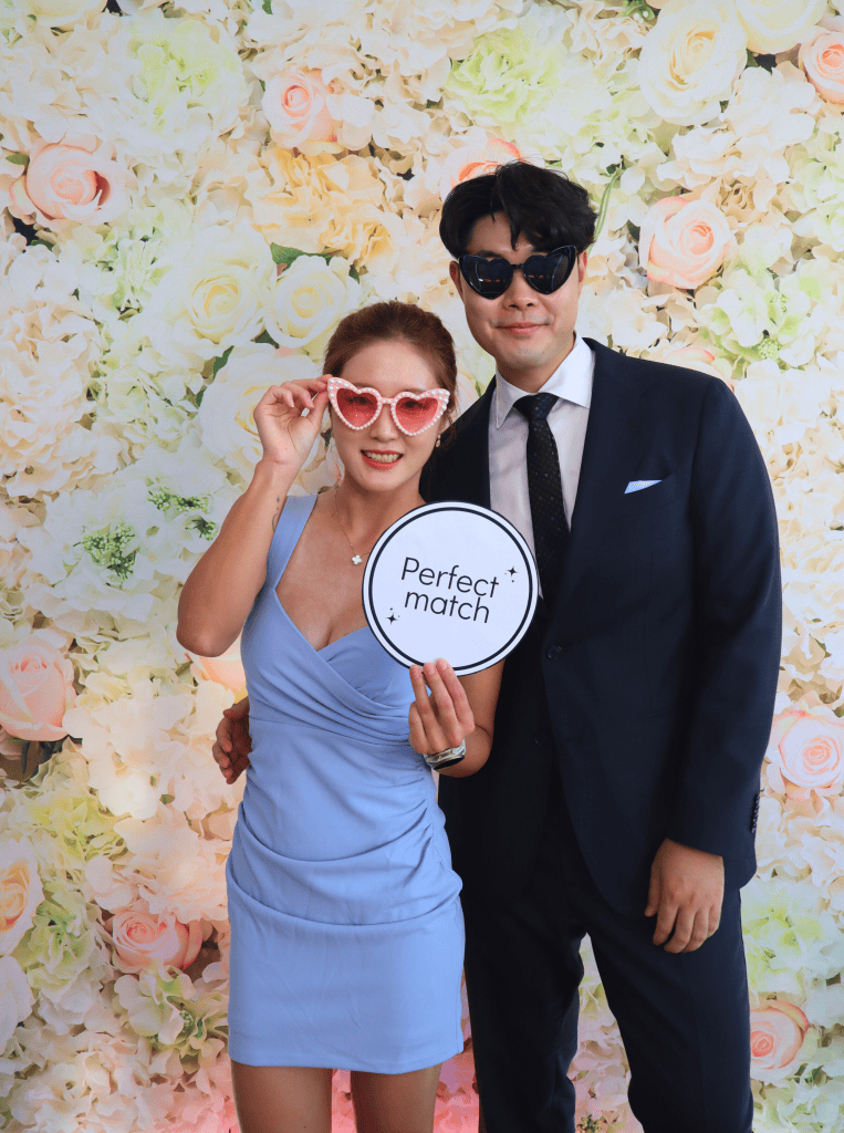 A couple posing for a photobooth photo at a wedding.